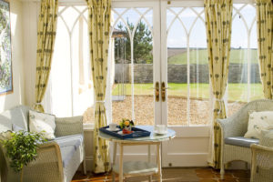 A bright sunny conservatory with comfortable seating