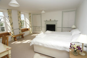A light and spacious bedroom with twin beds, and beautiful bay window seats