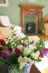 Fresh flowers in front of a fire place