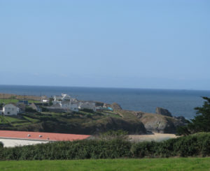 The stunning coastal view from Porthcothan House with sandy beach and bright green cliffs