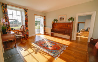 Front Hall in afternoon sun with Sitting Room in background.