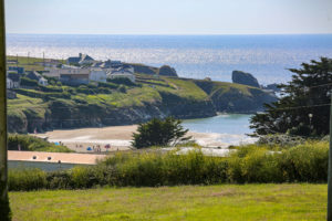 The stunning coastal view from Porthcothan House with sandy beach and bright green cliffs